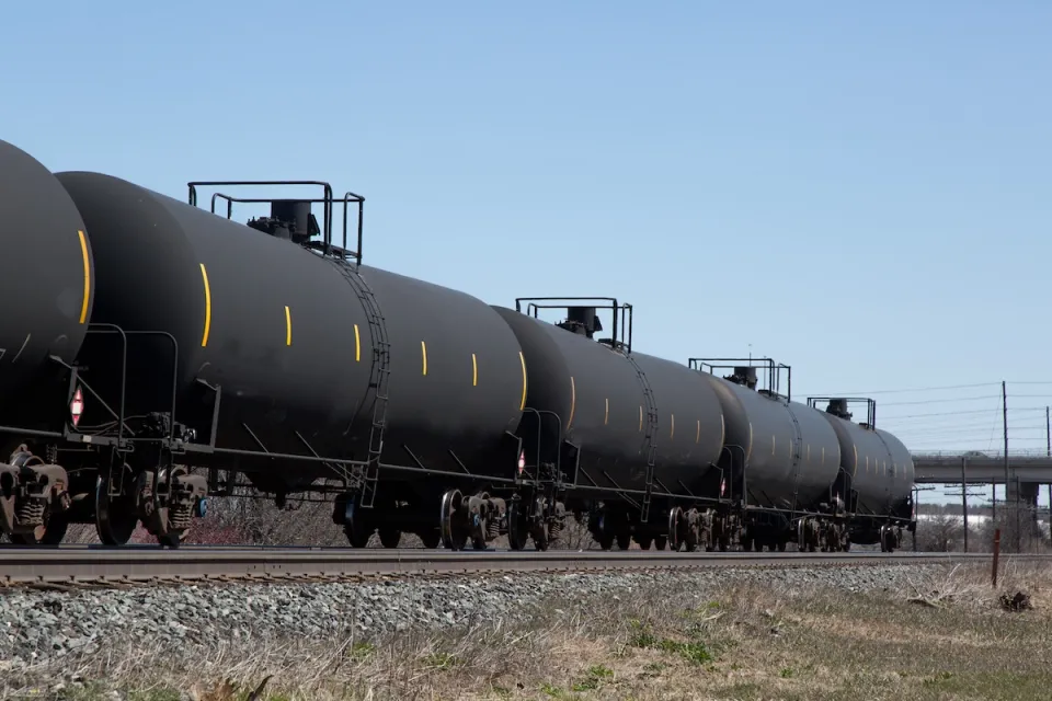 Train with black oil tankers.